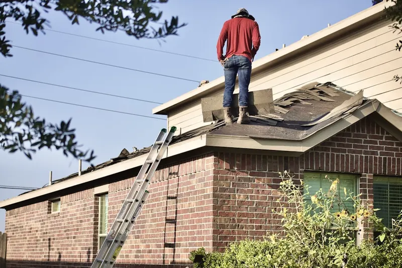Professional roofer working on a residential roof in Penfield